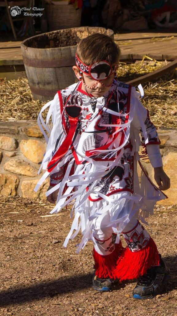 Young child Potawatomi Grass Dancer in regalia.